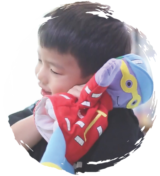 Young boy hugging a puppet character