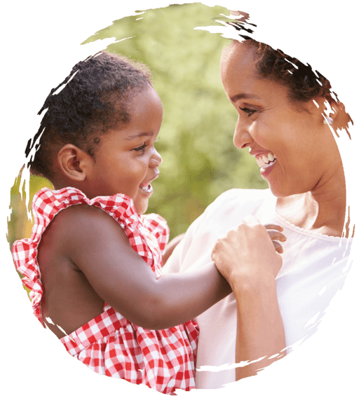 Parent smiling and carrying infant