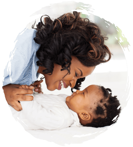 Parent playing with happy infant on mat